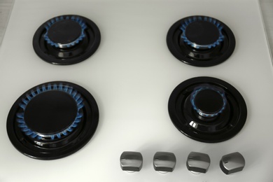 Gas burners with blue flame on modern stove