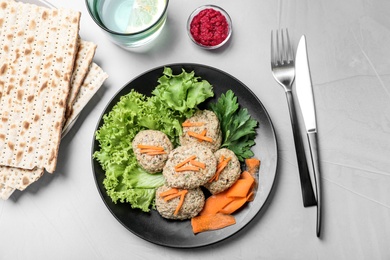 Photo of Flat lay composition with plate of traditional Passover (Pesach) gefilte fish  on light background