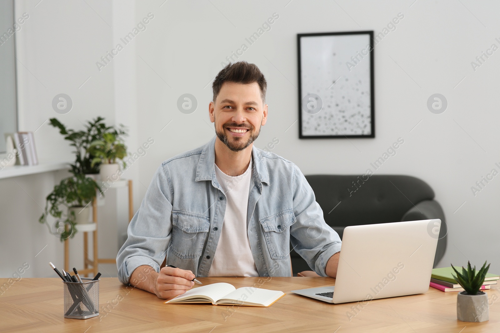 Photo of Man studying on laptop at home. Online translation course