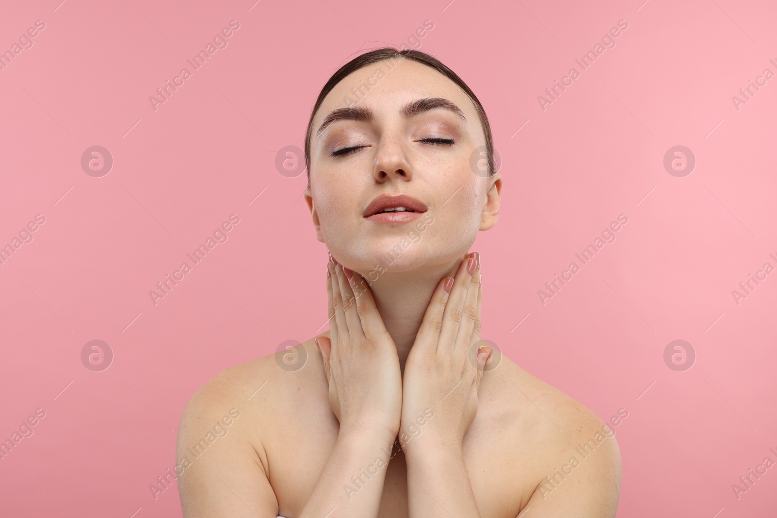 Photo of Beautiful woman touching her neck on pink background