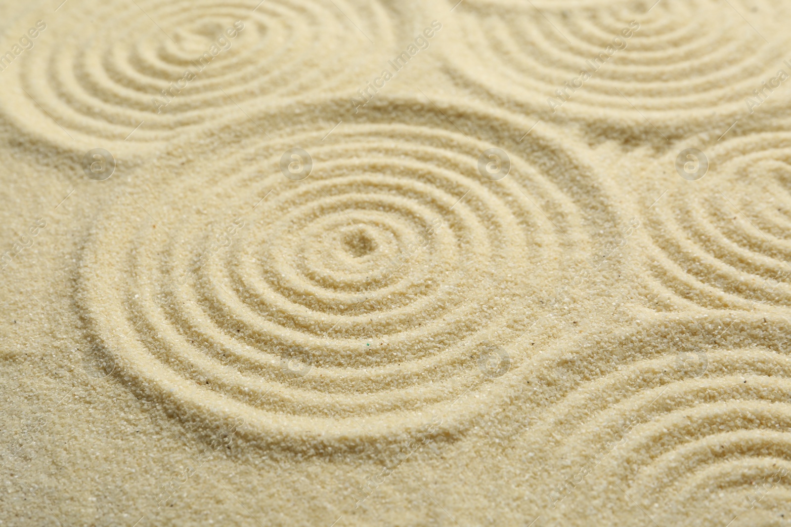 Photo of Zen rock garden. Circle patterns on beige sand