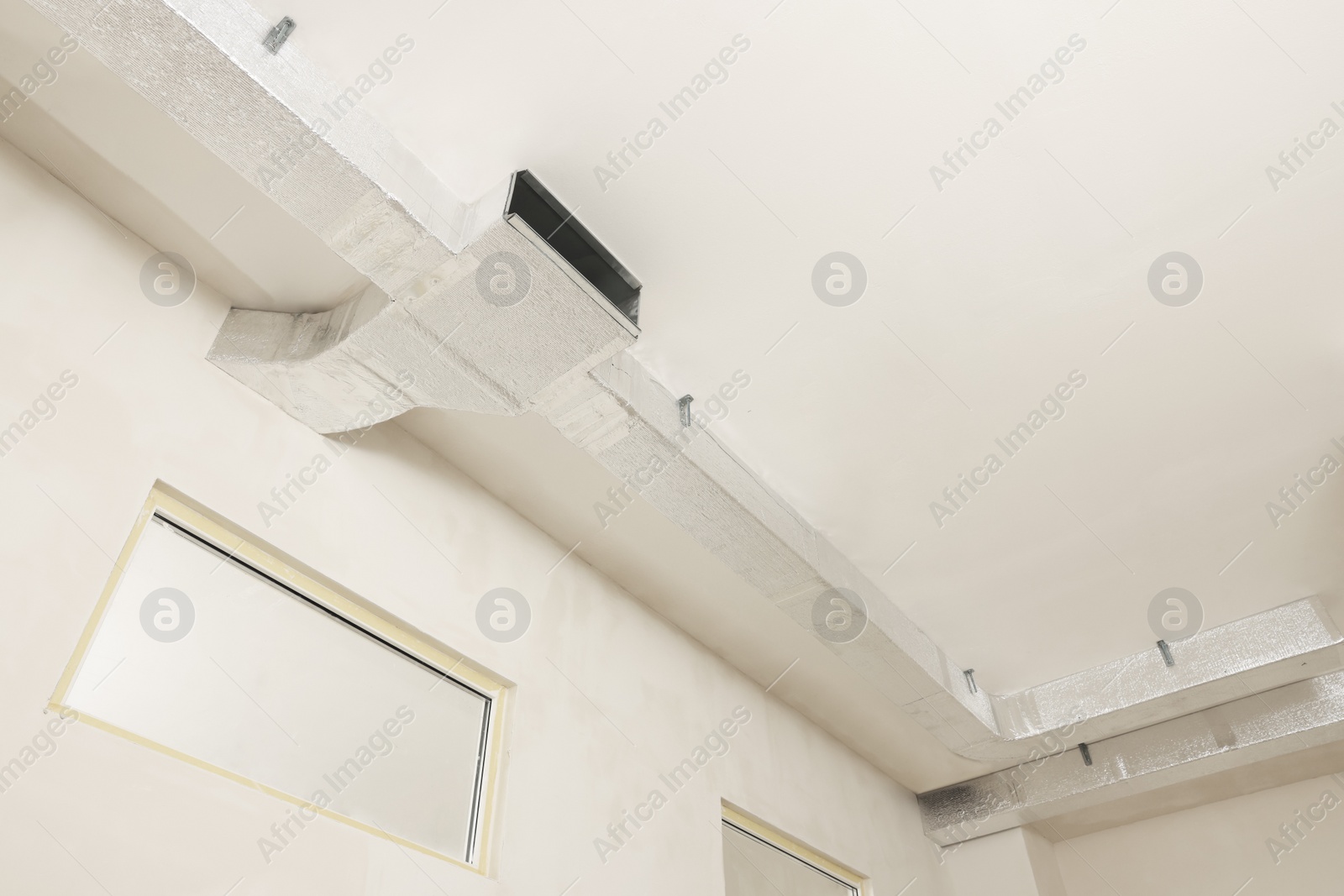 Photo of Ceiling with ventilation system indoors, low angle view