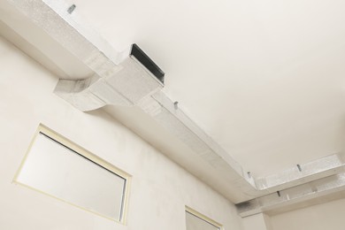 Photo of Ceiling with ventilation system indoors, low angle view