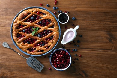 Delicious currant pie with fresh berries on wooden table, flat lay