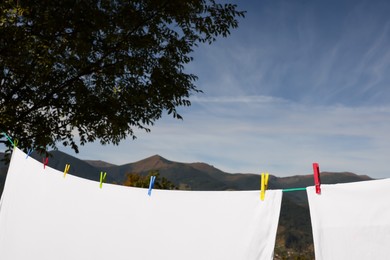 Laundry with clothes pins on line outdoors. Space for text