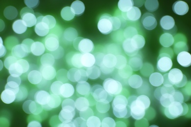 Photo of Blurred view of Christmas lights on green background