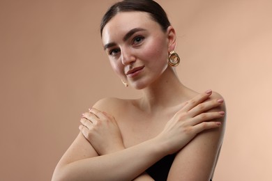 Portrait of beautiful young woman on beige background