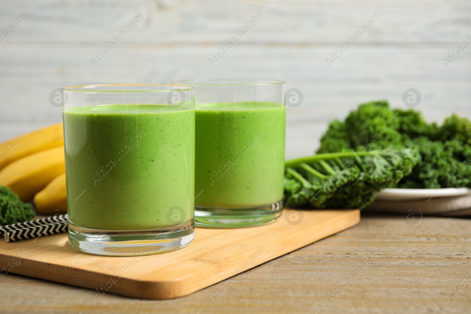 Photo of Tasty fresh kale smoothie on wooden table