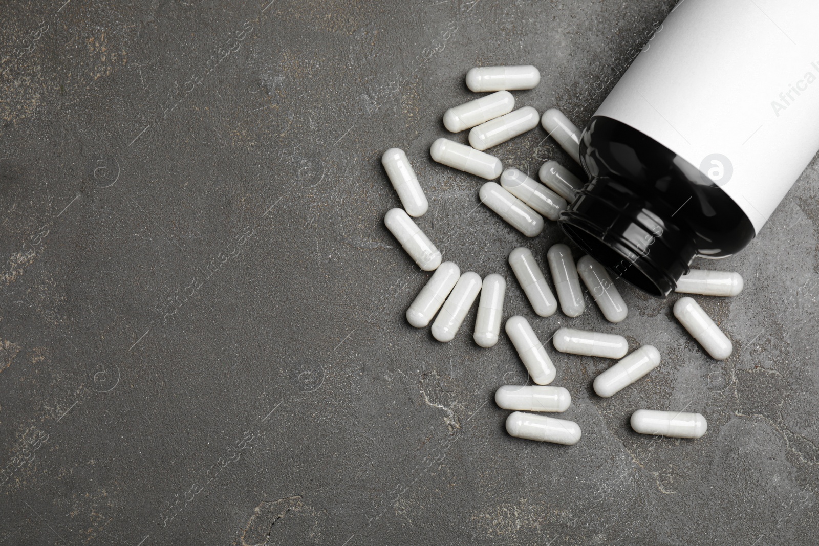 Photo of Amino acid pills on grey table, flat lay. Space for text