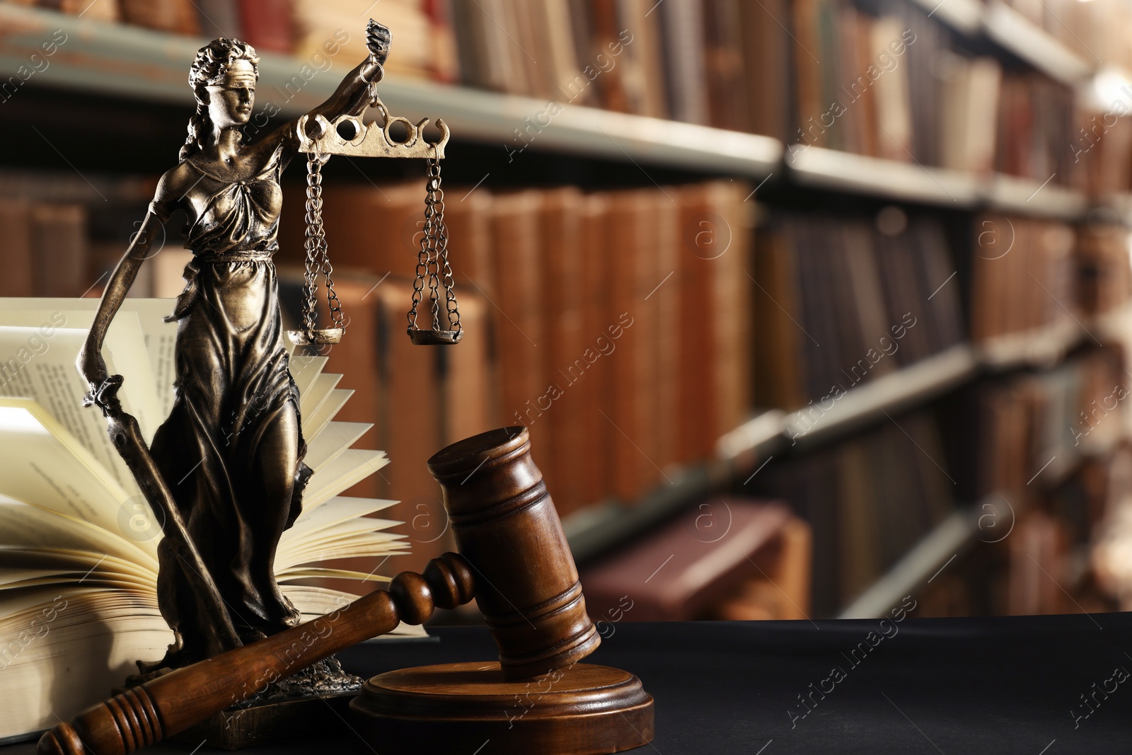 Image of Law. Statue of Lady Justice, gavel and open book on black table indoors, space for text