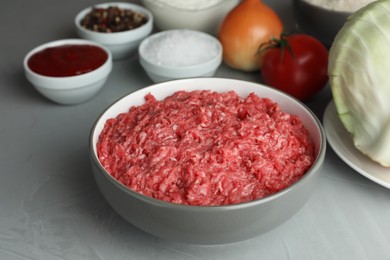 Set of ingredients for preparing stuffed cabbage rolls on light grey table