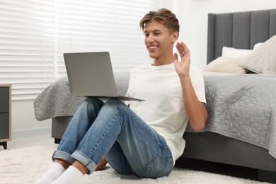 Happy young man having video chat via laptop indoors