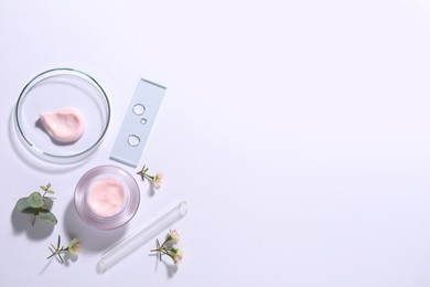 Organic cosmetic product, natural ingredients and laboratory glassware on white background, top view. Space for text