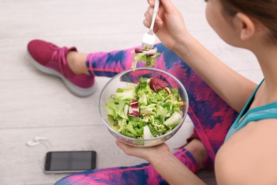 Photo of Young woman in fitness clothes having healthy breakfast at home, closeup