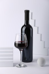 Photo of Stylish presentation of delicious red wine in bottle and glass on white background