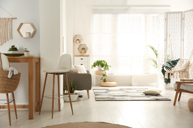 Stylish living room interior with comfortable sofa, table and chairs