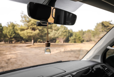Photo of Air freshener hanging on rear view mirror in car