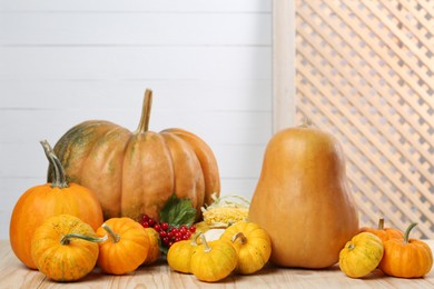 Photo of Happy Thanksgiving day. Composition with pumpkins and berries on wooden table