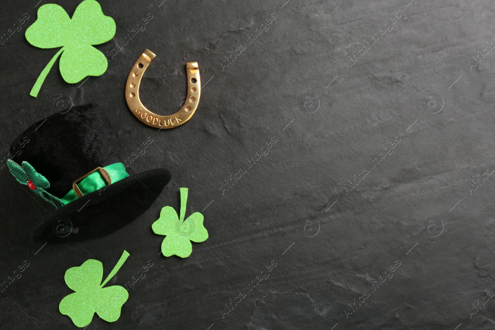 Photo of Leprechaun's hat and St. Patrick's day decor on black background, flat lay. Space for text