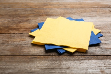 Photo of Clean paper napkins on wooden background. Personal hygiene