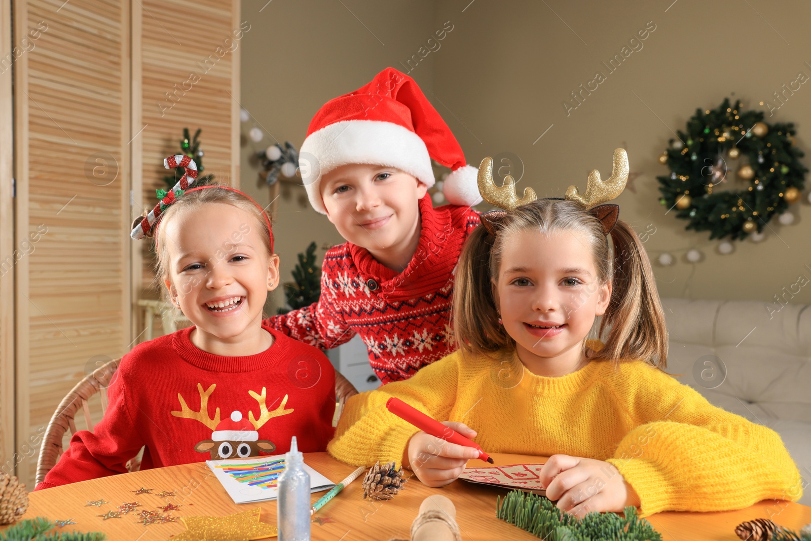 Photo of Cute little children making beautiful Christmas greeting cards at home