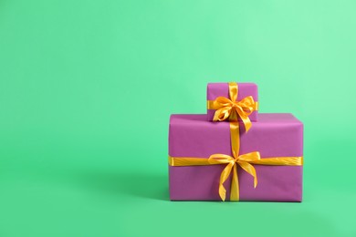 Photo of Beautifully wrapped gift boxes on green background. Space for text