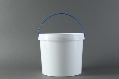 One plastic bucket with lid on grey background