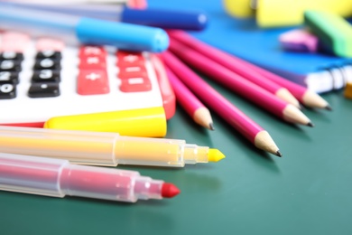 Photo of Different colorful stationery on chalkboard surface. Back to school