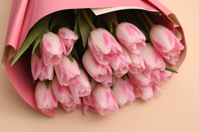 Photo of Beautiful bouquet of fresh pink tulips on beige background, closeup