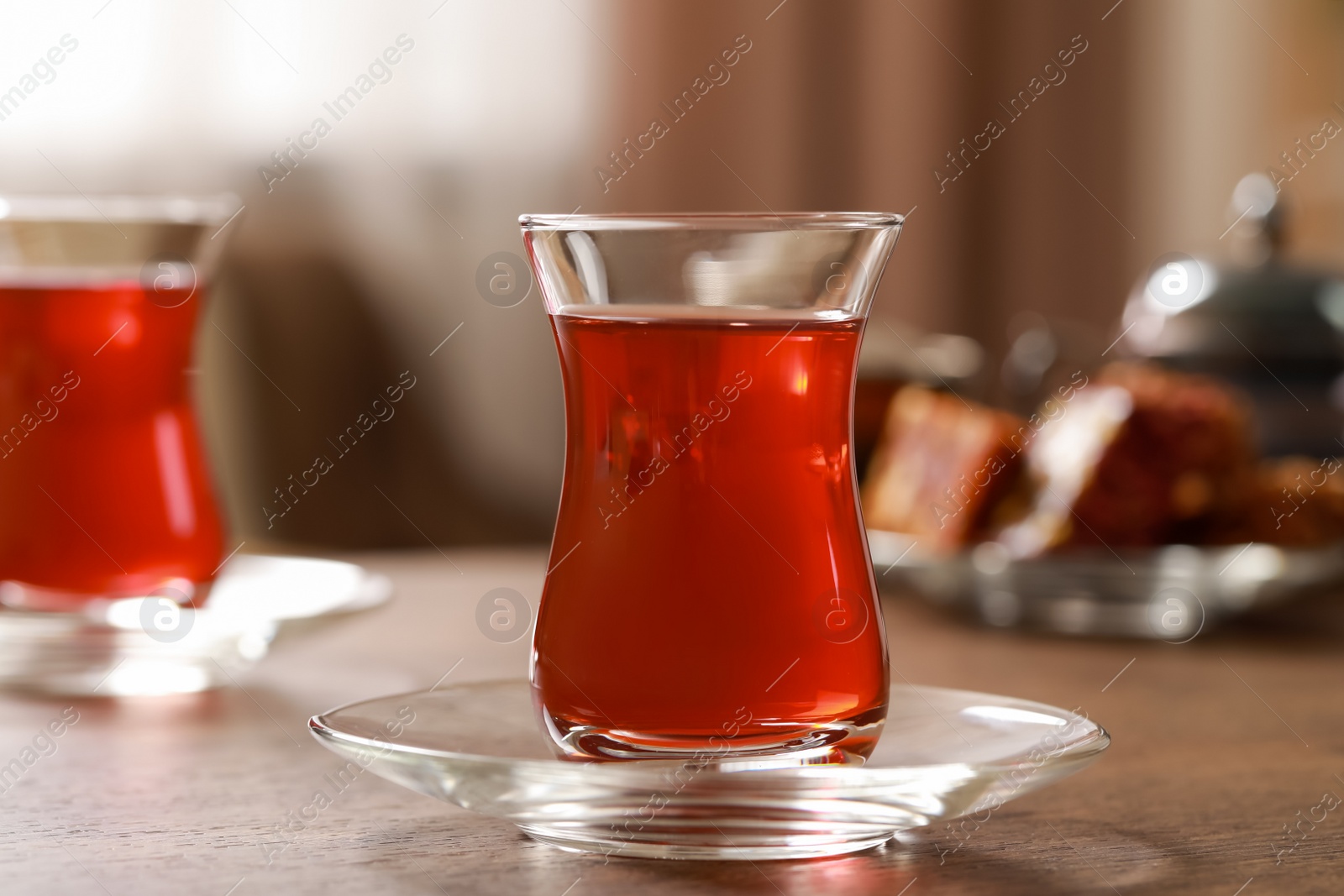 Photo of Glass of traditional Turkish tea on wooden table, closeup