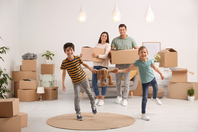 Photo of Happy family in room with cardboard boxes on moving day