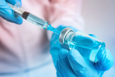 Image of Doctor filling syringe with medication, closeup. Vaccination and immunization