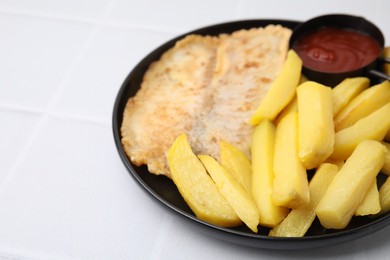 Photo of Delicious fish and chips with ketchup on white tiled table, closeup