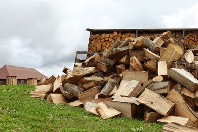 Photo of Pile of chopped firewood on grass outdoors
