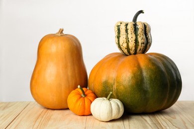 Photo of Thanksgiving day. Many different pumpkins on wooden table