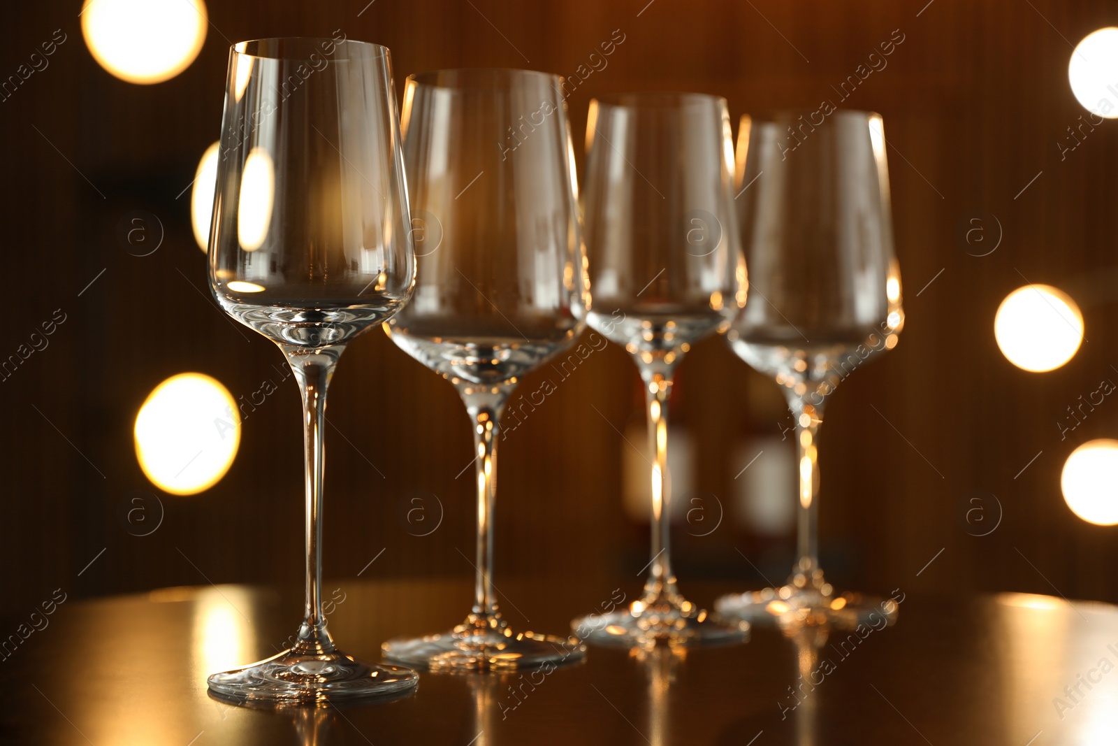 Photo of Empty wine glasses on table against blurred background