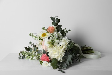 Photo of Bouquet of beautiful flowers on white wooden table