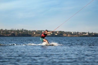 Photo of Man wakeboarding on river. Extreme water sport