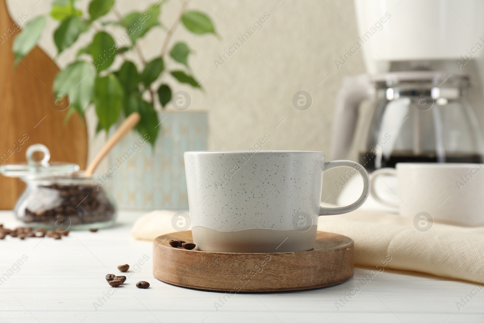 Photo of Cup of drink and coffee beans on white wooden table