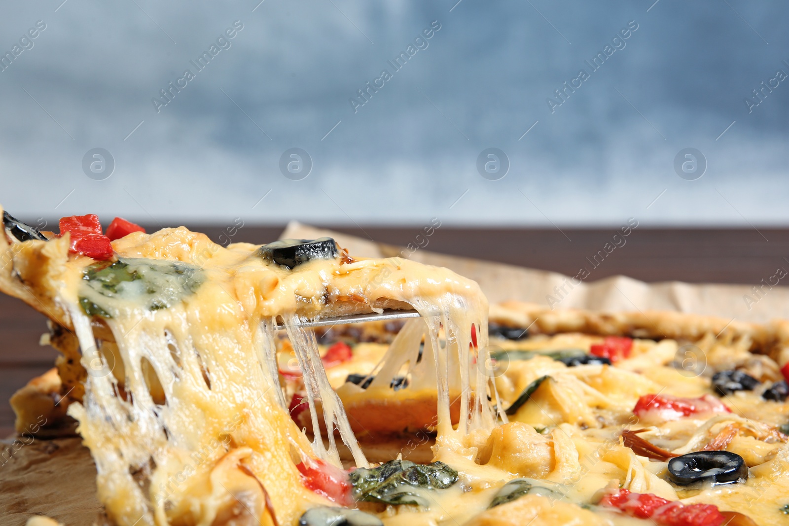 Photo of Taking delicious homemade pizza slice with melted cheese, closeup