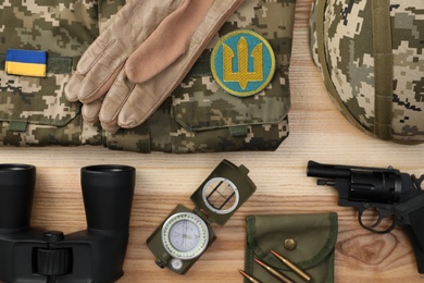 Photo of MYKOLAIV, UKRAINE - SEPTEMBER 26, 2020: Tactical gear, military uniform and Ukrainian army patches on table, flat lay
