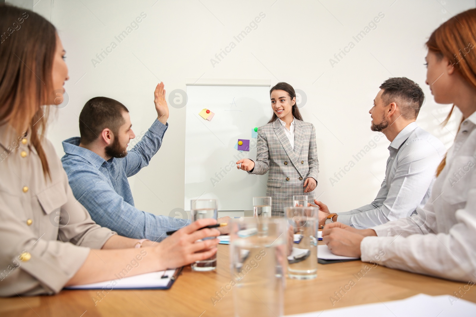 Photo of Man raising hand to ask question at business training in conference room