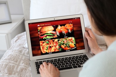 Photo of Woman using laptop for ordering food online at home, closeup. Concept of delivery service