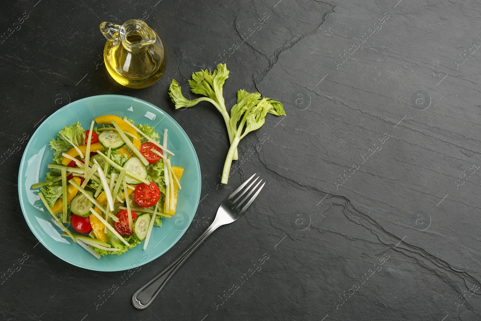 Photo of Delicious fresh celery salad served on black table, flat lay. Space for text