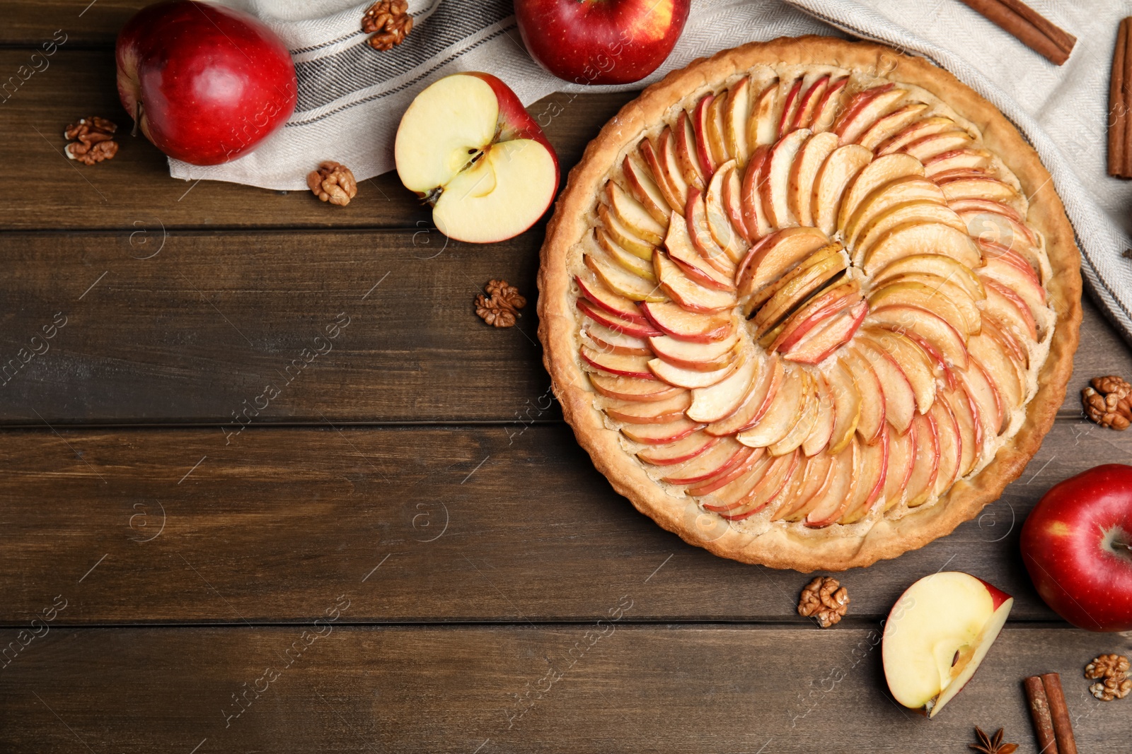 Photo of Flat lay composition with delicious homemade apple tart on wooden table. Space for text