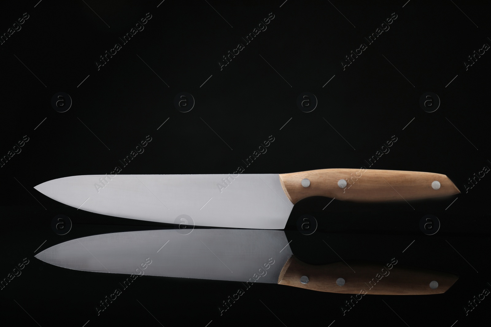 Photo of Sharp knife with wooden handle on black reflective surface