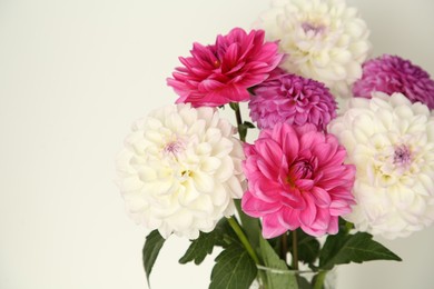 Photo of Bouquet of beautiful Dahlia flowers near white wall, closeup