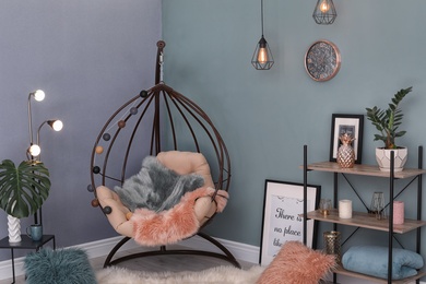 Photo of Elegant living room interior with hanging armchair and fuzzy rug