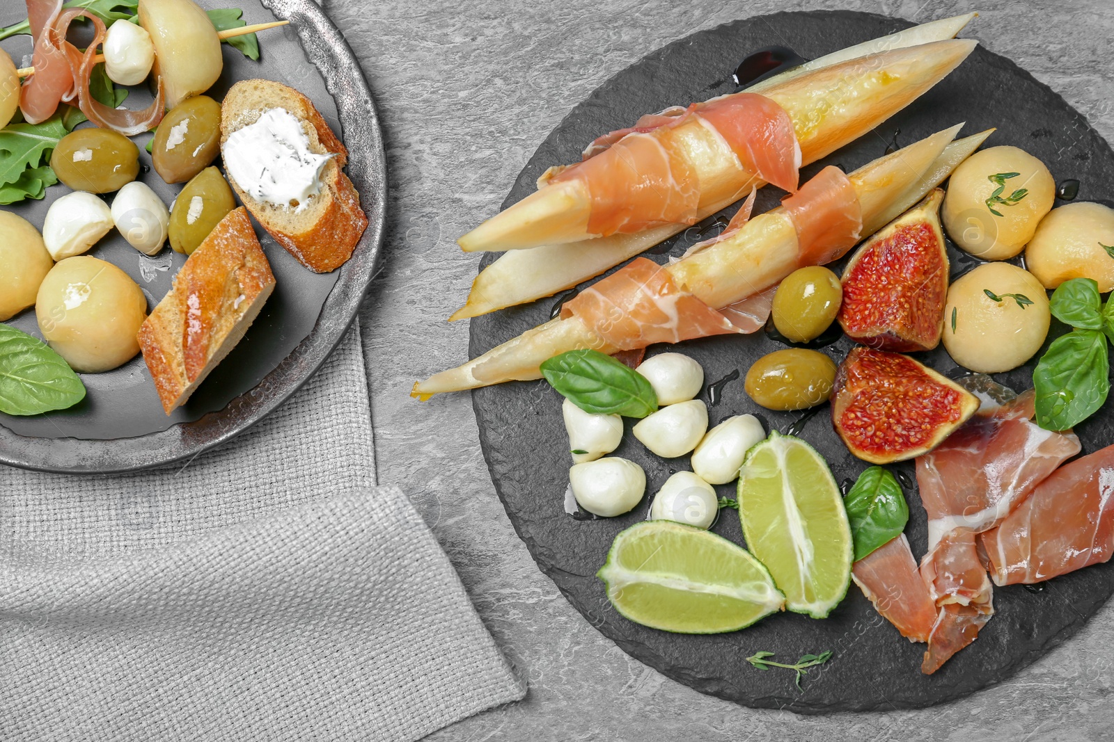 Photo of Flat lay composition with melon and prosciutto appetizer served on table