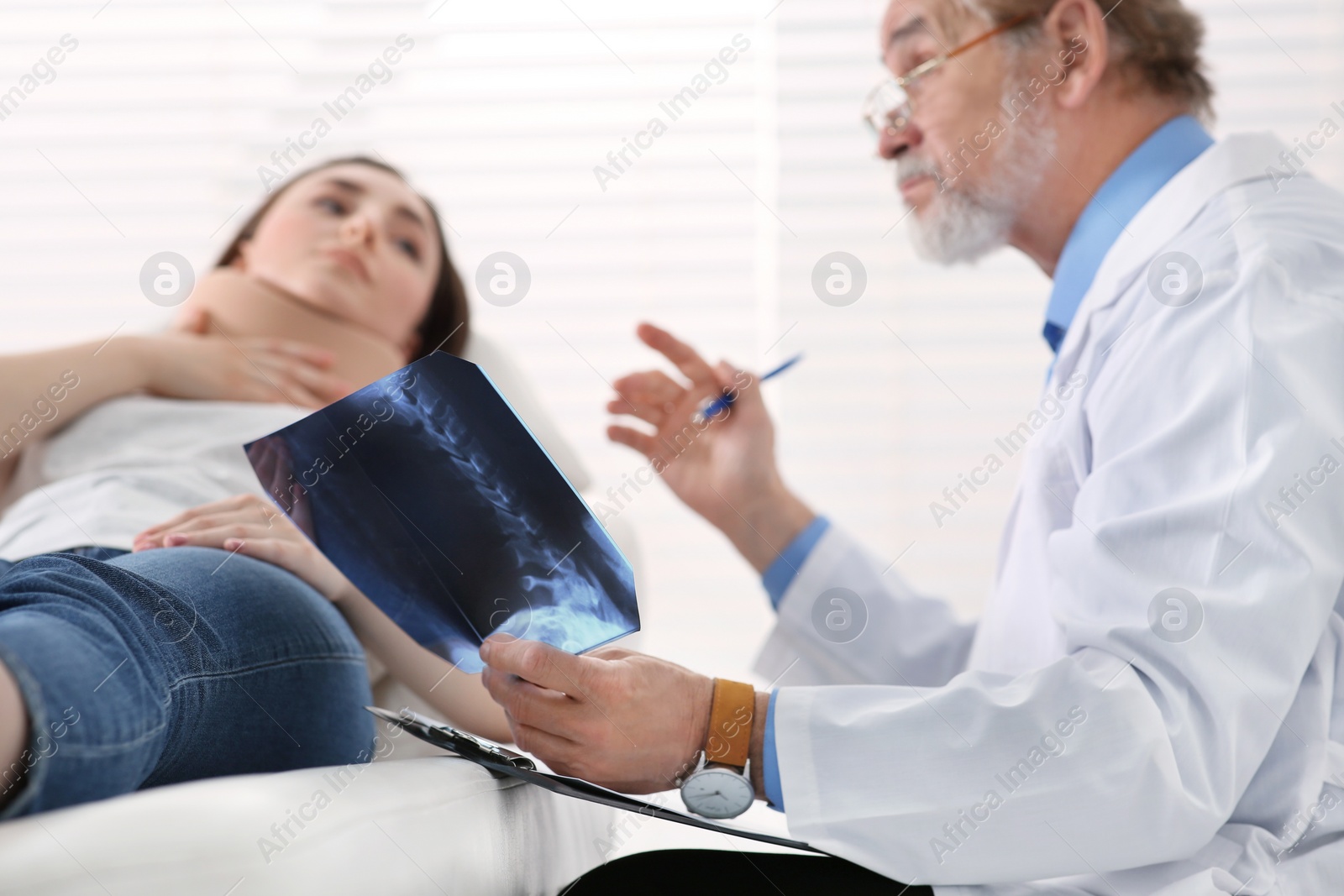 Photo of Orthopedist showing X-ray picture to patient in clinic